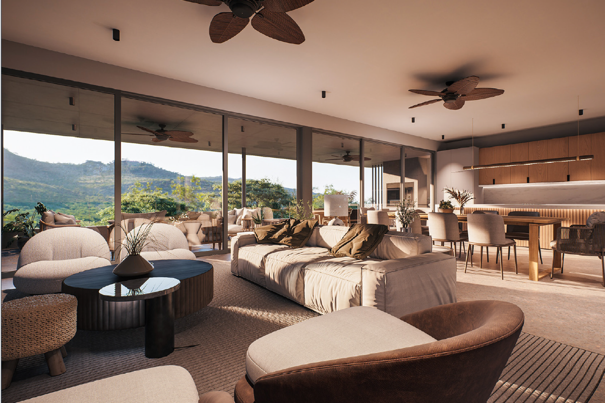 Spacious open-plan living and kitchen area featuring floor-to-ceiling glass doors, modern cabinetry, and ceiling fans, offering seamless indoor-outdoor flow with scenic views.