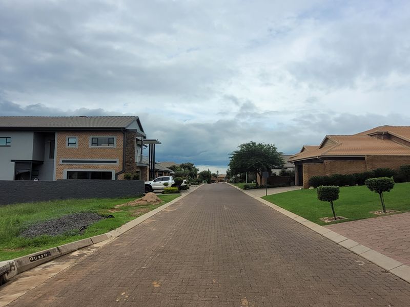 A view of the paved residential street within the estate, featuring well-maintained verges and established surrounding residential properties.