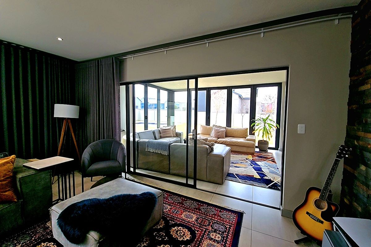 Spacious living area featuring large sliding glass doors that provide seamless access to an enclosed patio, creating a bright and connected indoor-outdoor flow.