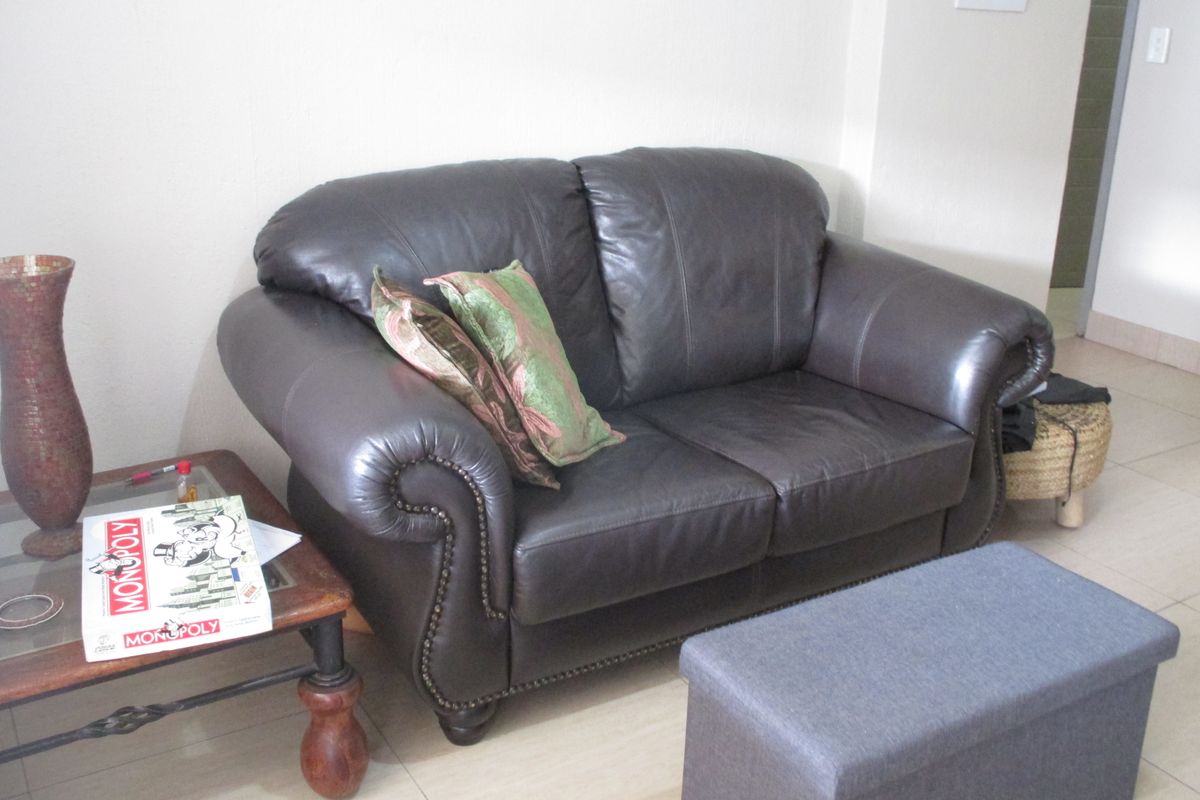 A living room area featuring neutral tiled flooring and a wall-mounted intercom system.
