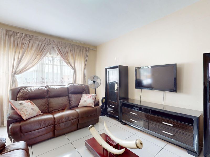 A living room featuring tiled flooring and neutral wall finishes, providing a functional and well-lit space for relaxation.