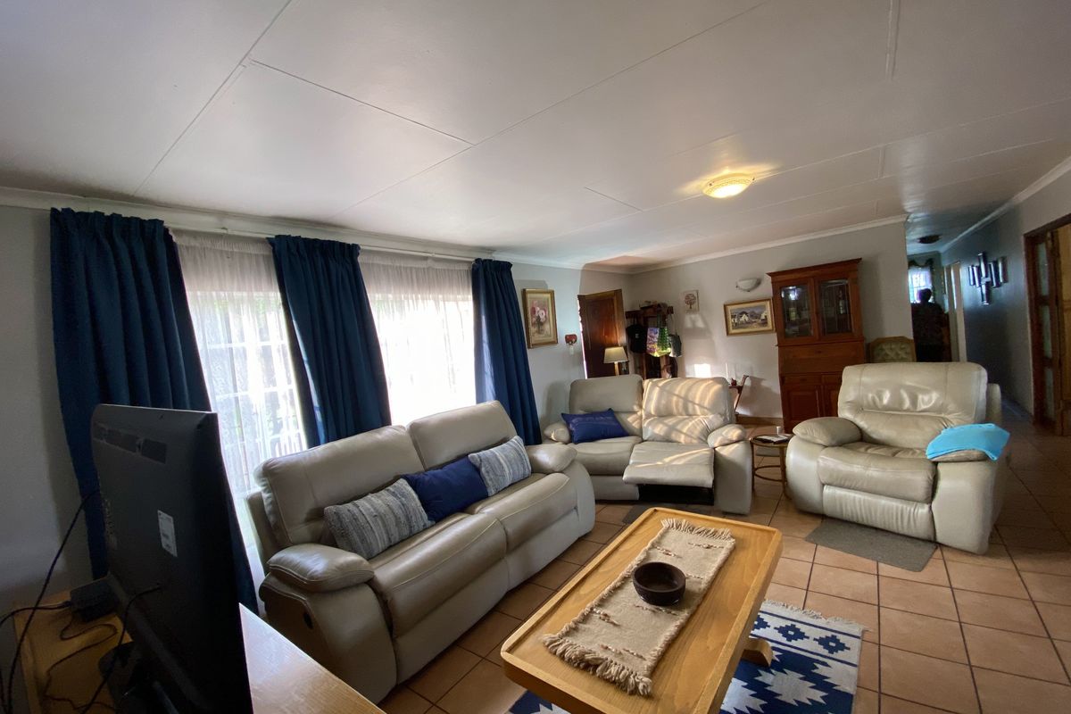 A spacious living room featuring tiled flooring and natural light, providing a comfortable and functional area for relaxation.