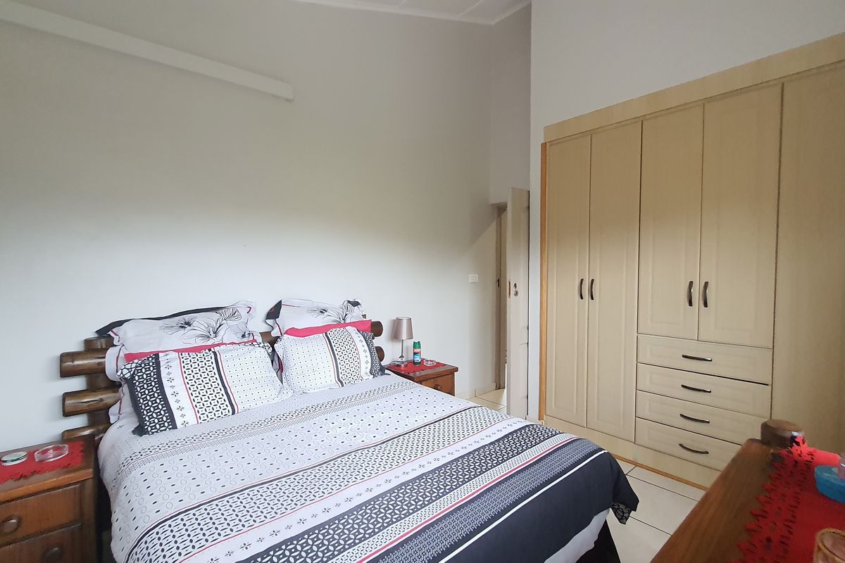A bedroom featuring neutral walls and extensive built-in cupboard storage with integrated drawers.