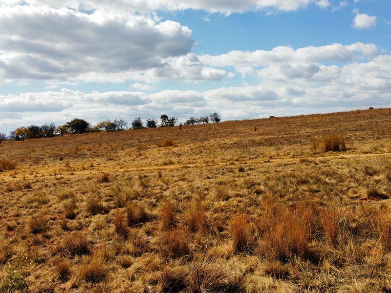 A wide-angle view of the vacant residential land, showcasing the natural topography and open landscape of the property.