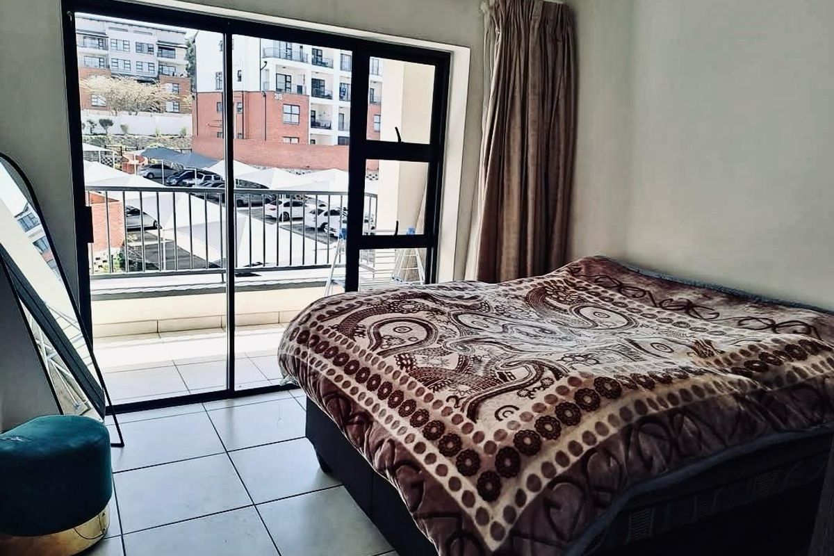 Bedroom featuring tiled flooring and large sliding glass doors providing access to a private balcony with exterior views.