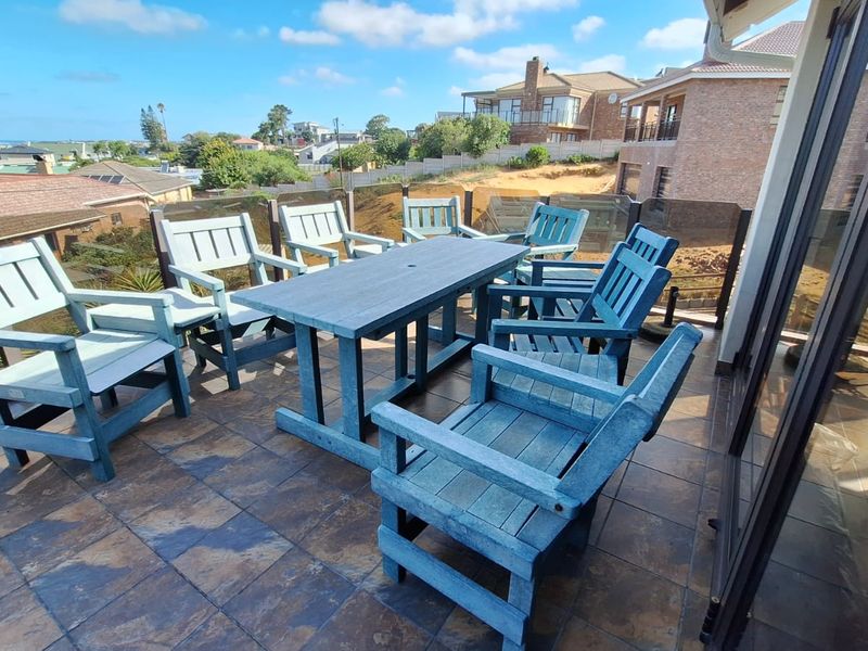 Spacious elevated balcony featuring tiled flooring and a glass balustrade, offering an open outdoor area perfect for entertaining with neighbourhood views.
