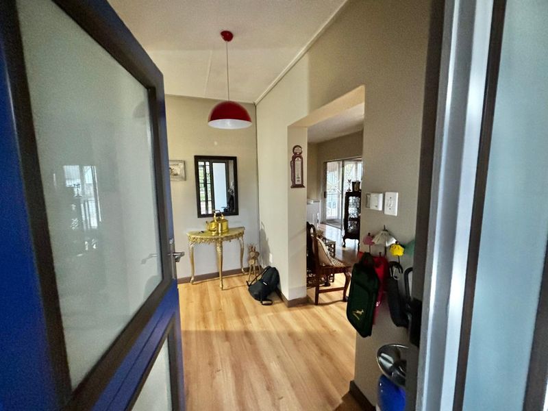 Entrance hall featuring laminate flooring and a pendant light, providing a welcoming transition into the main living areas of the home.