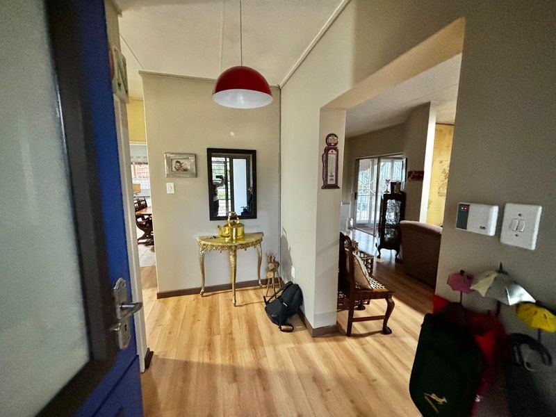 Entrance hall featuring laminate flooring and a pendant light fixture, providing a welcoming transition into the main living areas of the home.