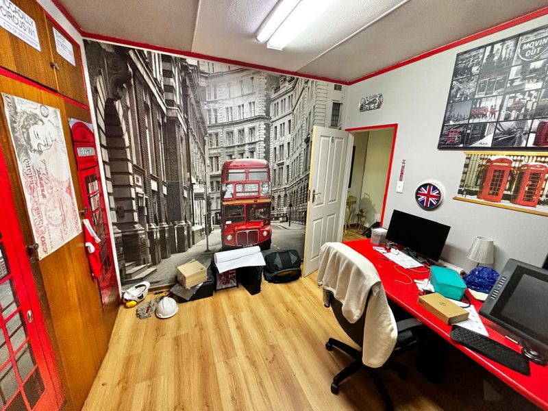 A functional office space featuring laminate flooring and a large feature wall mural, suitable for a home workspace or study area.