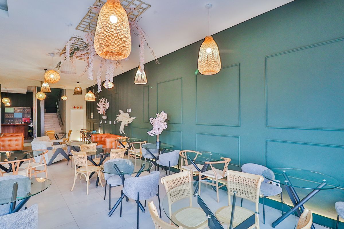 A spacious open-plan living area featuring decorative wall paneling, tiled flooring, and modern pendant lighting, suitable for a lounge or dining space.