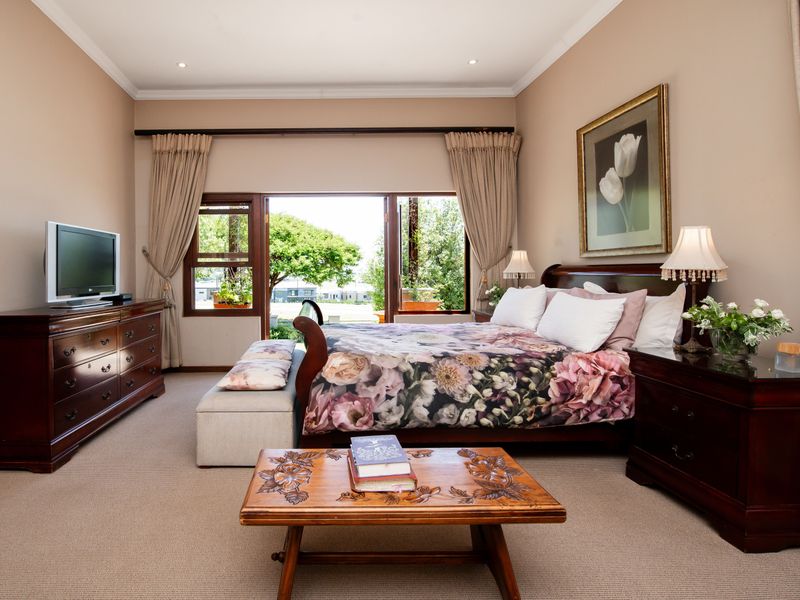 Spacious bedroom featuring neutral walls, carpeted flooring, and large sliding glass doors that provide direct access to the outdoor area.