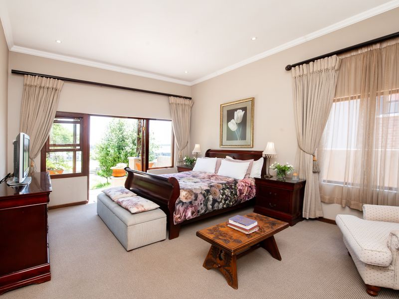 Spacious bedroom featuring neutral carpeting, crown molding, recessed lighting, and sliding glass doors providing direct access to the outdoor area.