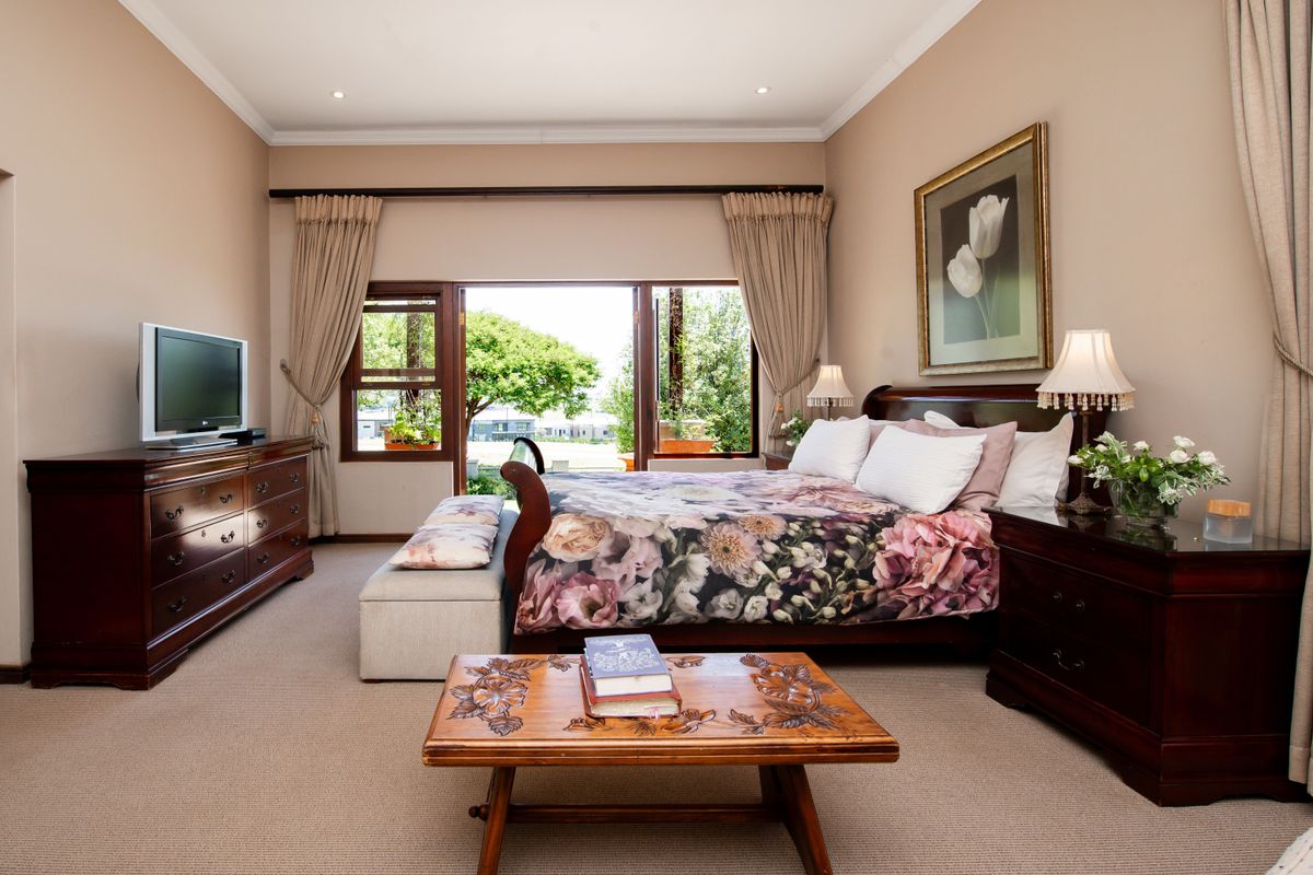 Spacious bedroom featuring neutral walls, carpeted flooring, and large sliding glass doors that provide direct access to the outdoor area.