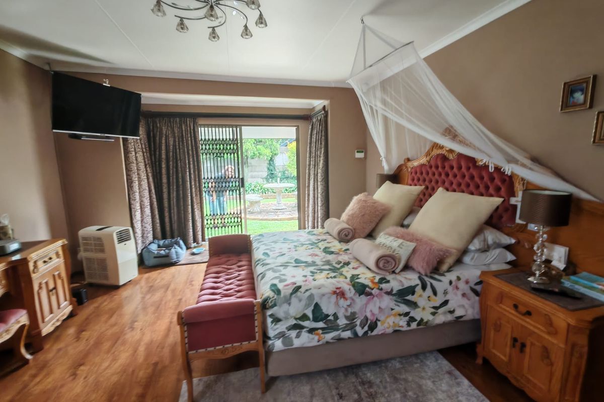 Spacious bedroom featuring laminate flooring and a sliding glass door providing direct access to the rear garden area.