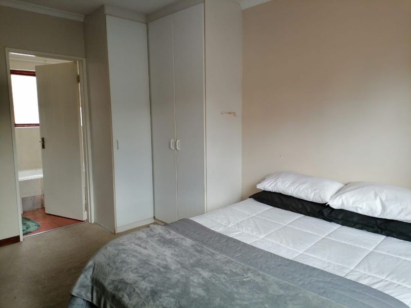 A bedroom featuring built-in cupboards and direct access to an en-suite bathroom.