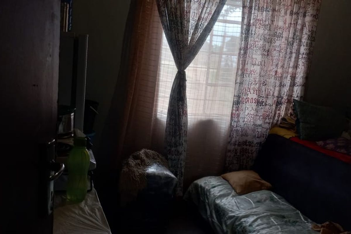 A bedroom featuring a window with curtains, providing natural light to the space.