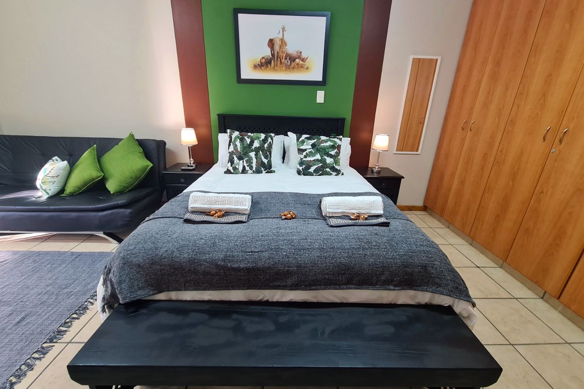 A bedroom featuring tiled flooring and built-in wooden cupboards, providing functional storage space.