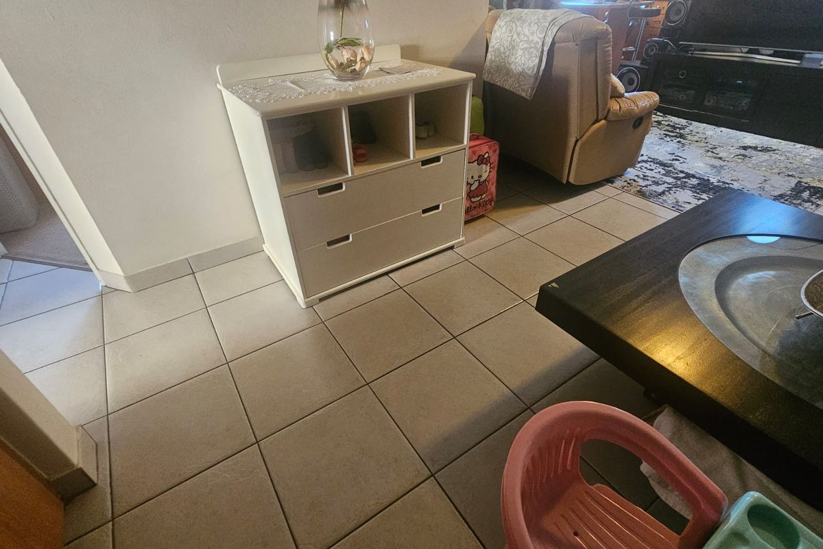 A living area featuring neutral ceramic floor tiles, providing a functional base for the space.