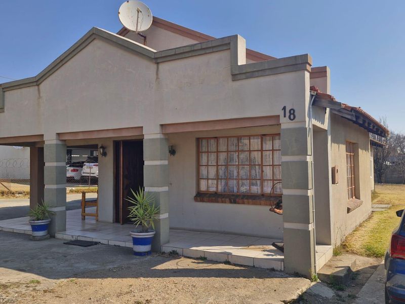 Front exterior view of a single-story house featuring a covered entrance porch, tiled flooring, and a satellite dish mounted on the roof.