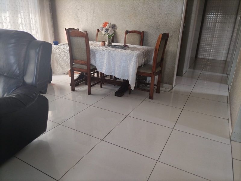 Dining area featuring large format porcelain floor tiles and a textured wall finish, providing a neutral base for interior updates.
