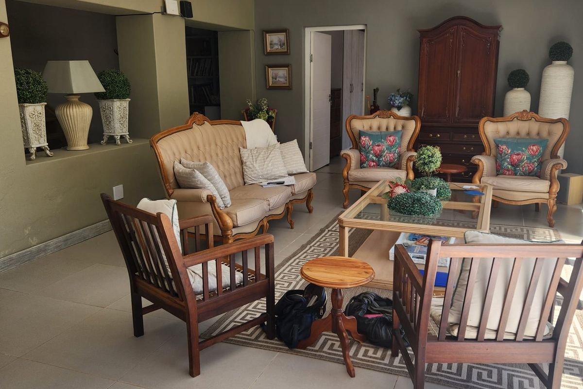 A spacious living room featuring neutral tiled flooring, recessed ceiling lighting, and a built-in wall niche, offering a comfortable and functional living space.