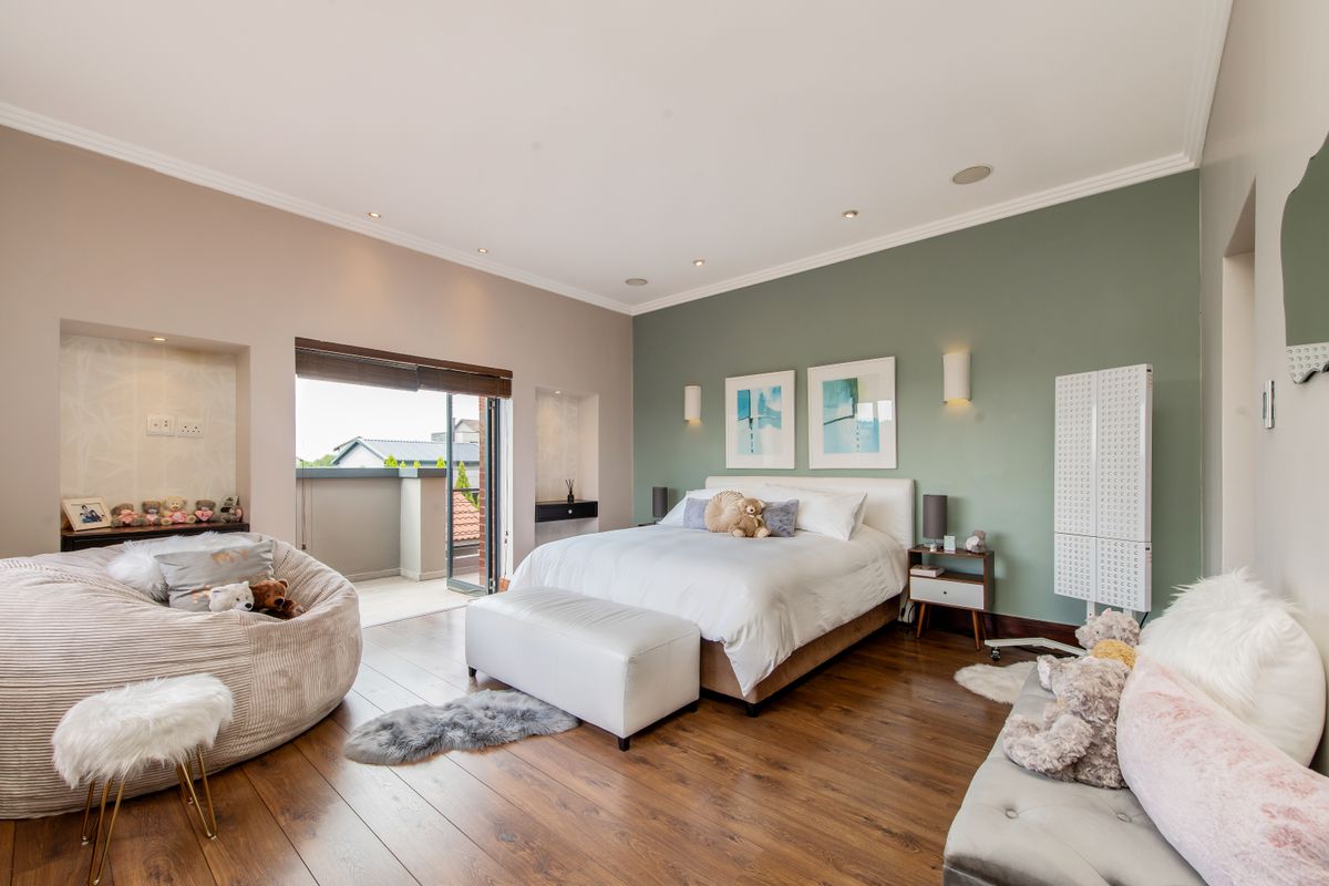 Spacious bedroom featuring hardwood flooring, recessed lighting, and direct access to a private balcony through sliding glass doors.