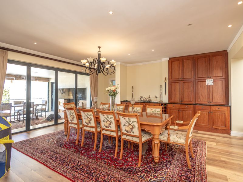 Spacious dining room featuring built-in wooden cabinetry, recessed lighting, and large sliding glass doors that open to an outdoor patio area.