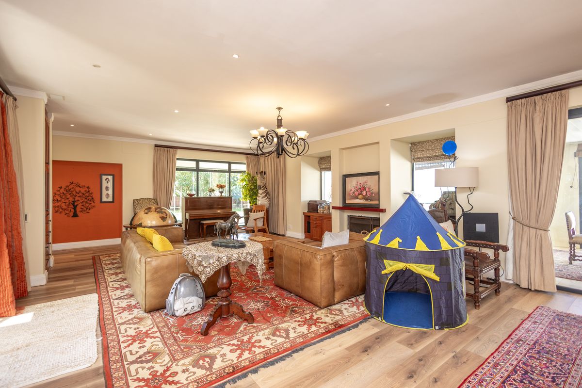 Spacious living room featuring timber flooring, a fireplace, and large sliding glass doors that provide ample natural light and access to the outdoors.