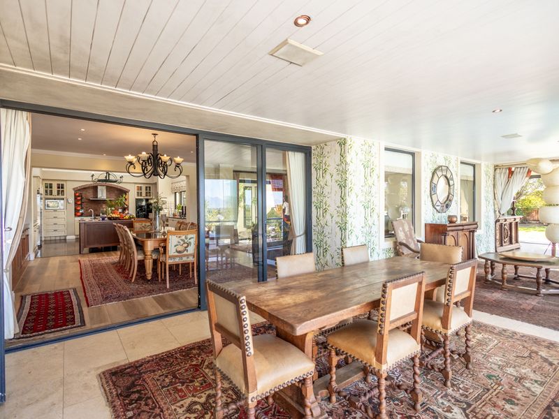 Spacious covered patio featuring large sliding glass doors that open into the interior living and kitchen area, with tiled flooring and recessed lighting.