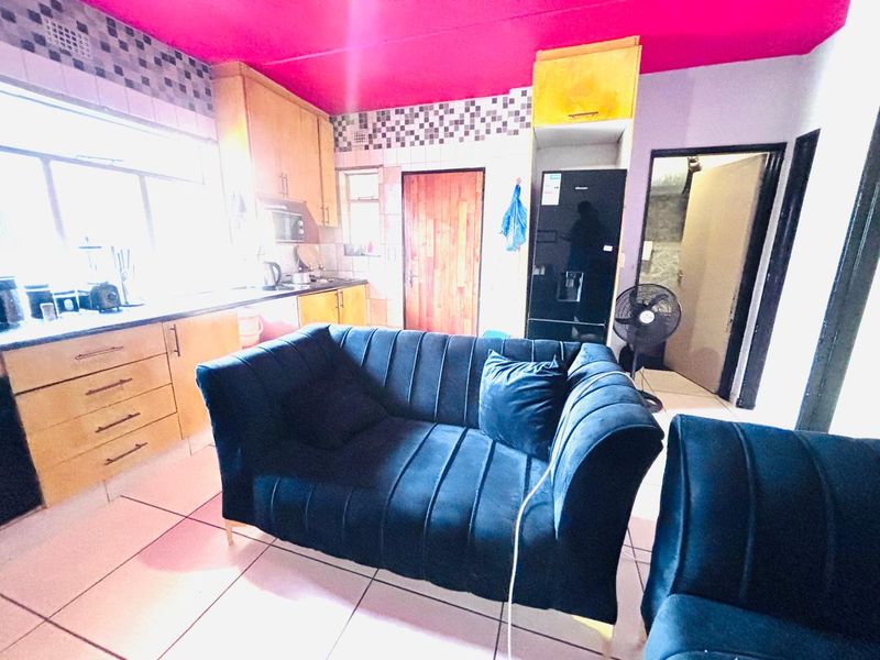 Open plan kitchen and living area featuring tiled flooring, built-in cabinetry, and direct access to adjacent rooms.