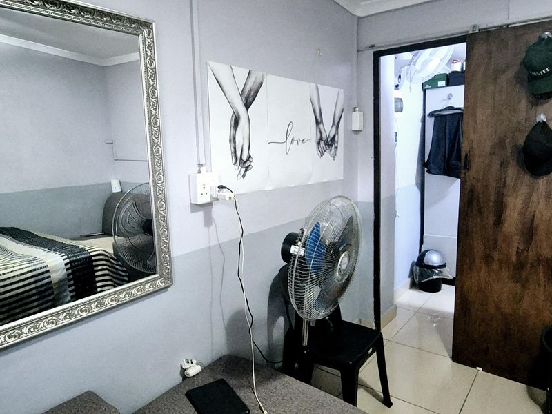 A bedroom featuring tiled flooring and a sliding door, with visible electrical conduit along the wall.