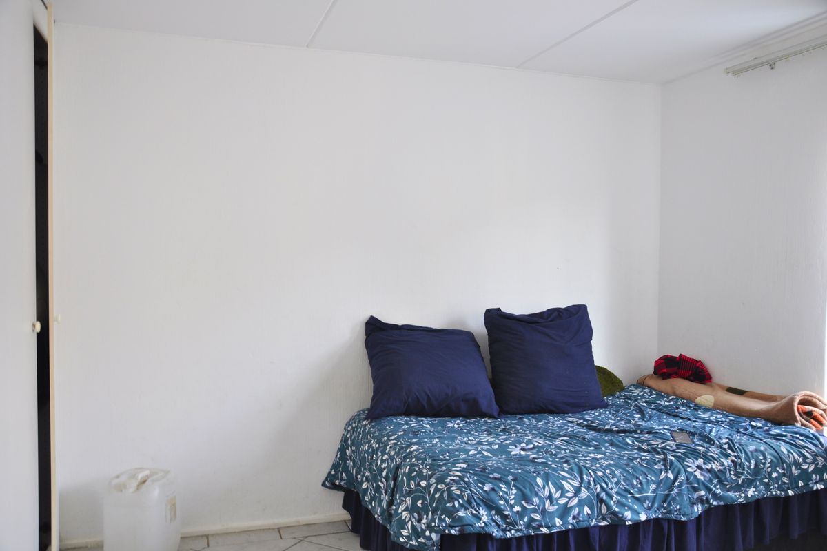 A simple bedroom featuring tiled flooring and a built-in closet, offering a neutral base for personalization.