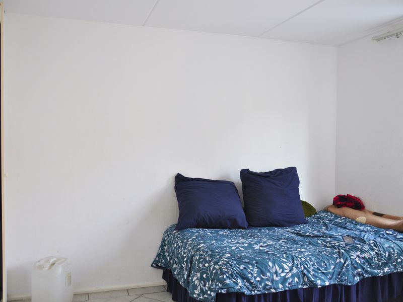 A simple bedroom featuring tiled flooring and a built-in closet, offering a neutral base for personalization.