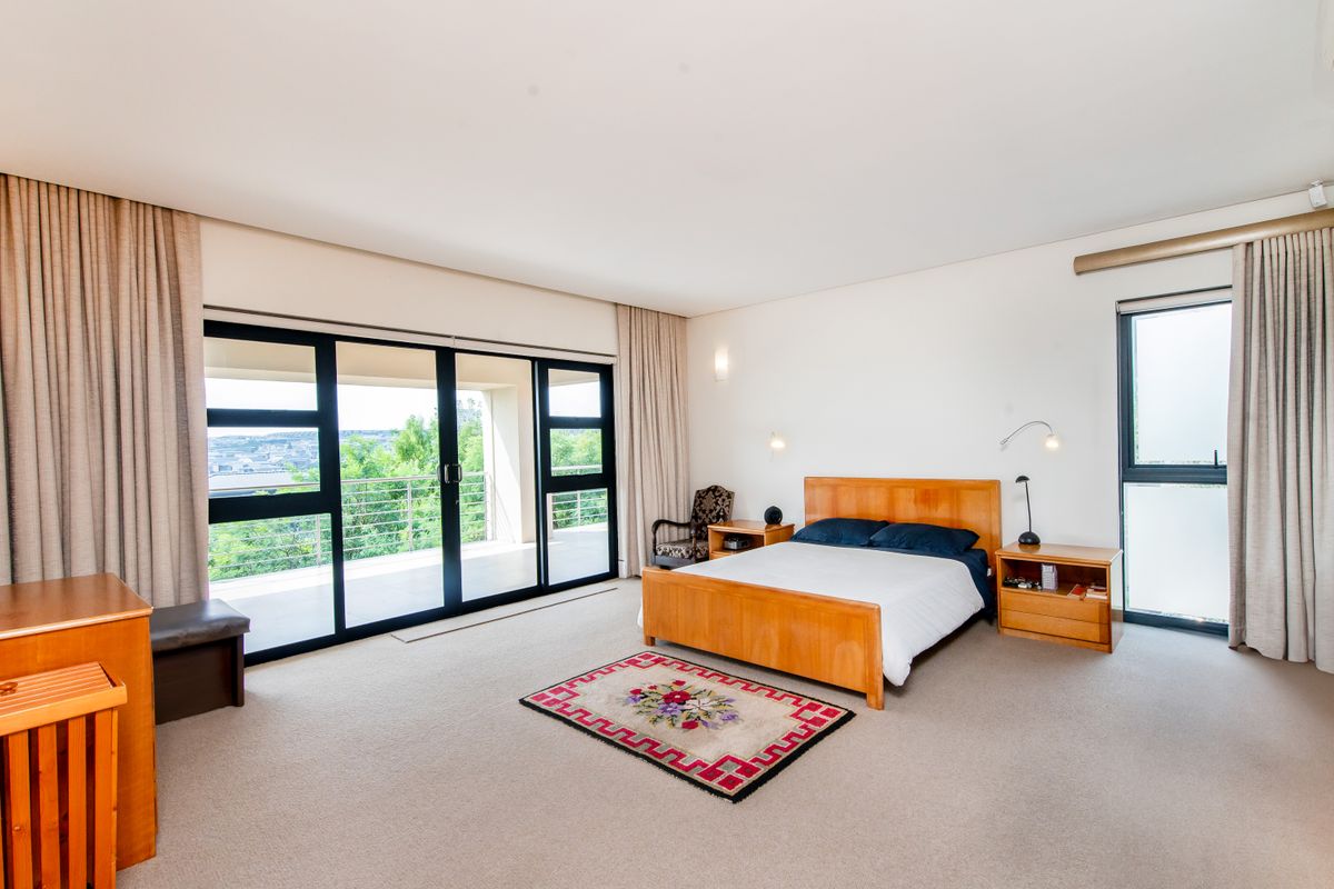 Spacious bedroom featuring large sliding glass doors opening onto a private balcony with scenic views and neutral carpeting.