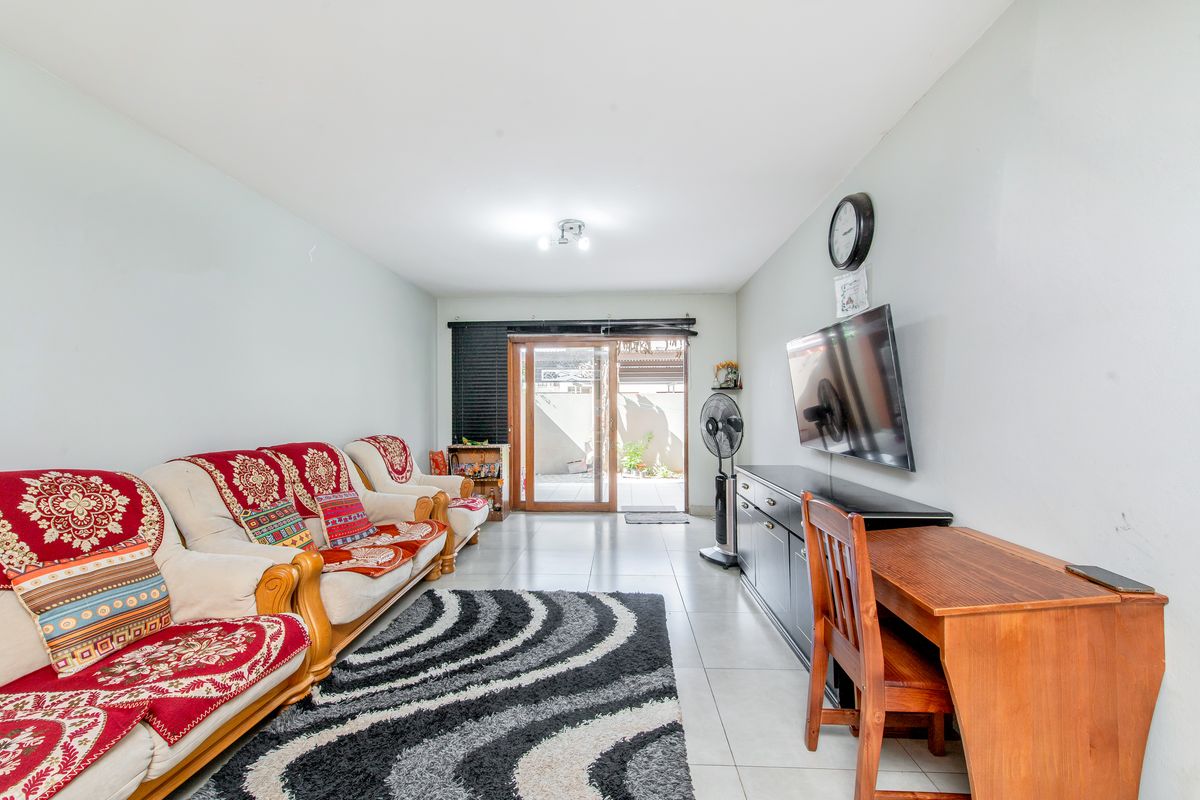 A functional living room featuring tiled flooring and a sliding glass door providing direct access to the outdoor patio area.