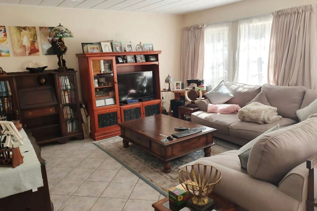A comfortable living room featuring tiled flooring and a panelled ceiling, offering a functional space for relaxation and entertainment.