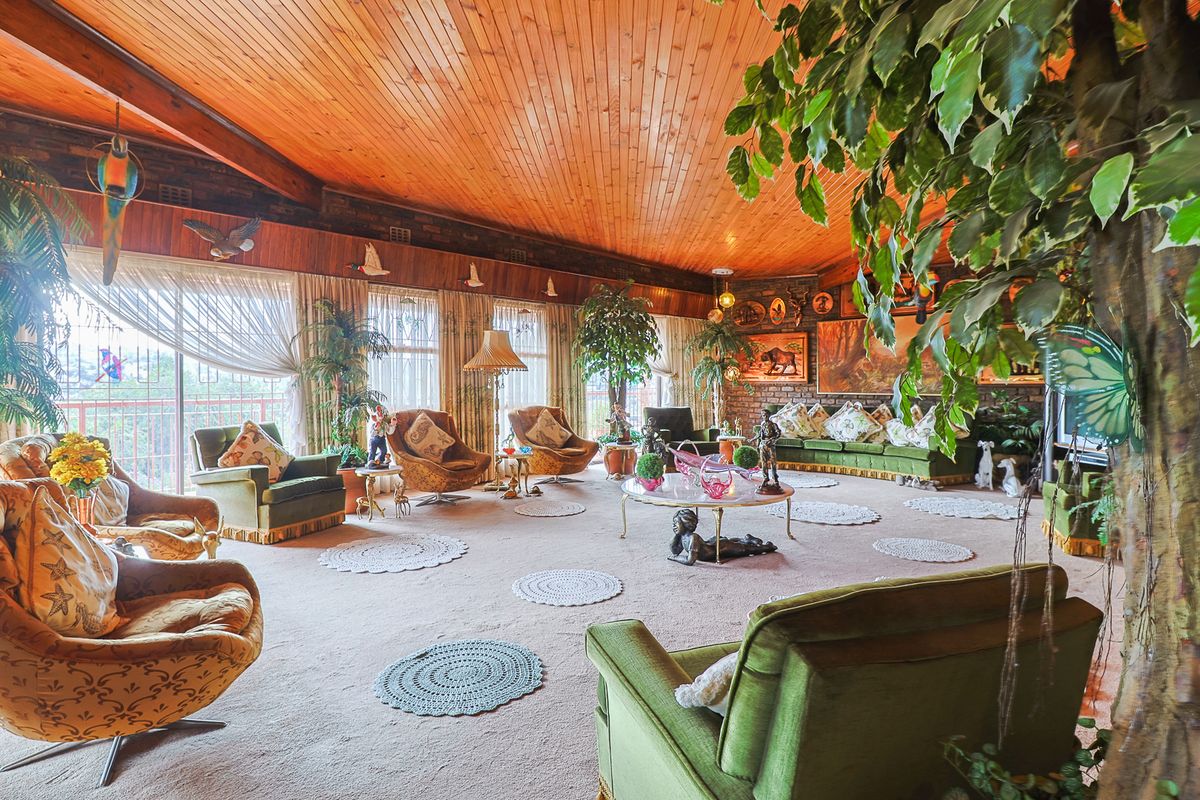 Spacious living room featuring exposed brick walls, a timber-clad ceiling with exposed beams, and large sliding glass doors providing natural light.