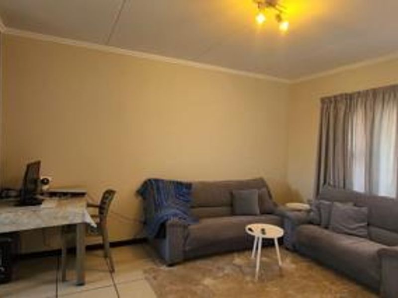 A functional living room featuring tiled flooring and neutral wall finishes, providing a comfortable and versatile space for relaxation.