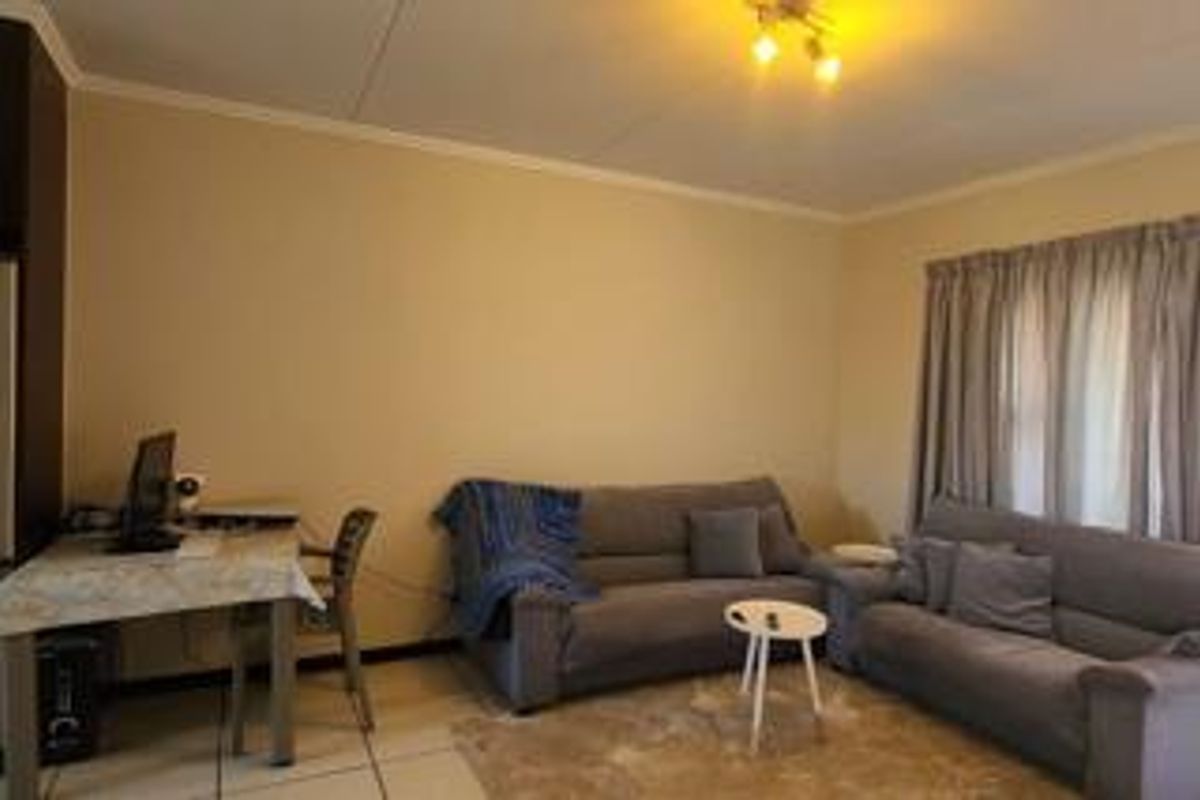 A functional living room featuring tiled flooring and neutral wall finishes, providing a comfortable and versatile space for relaxation.