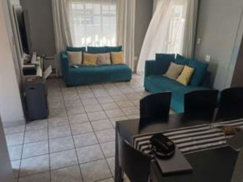Open-plan living and dining area featuring tiled flooring and large sliding glass doors providing natural light.