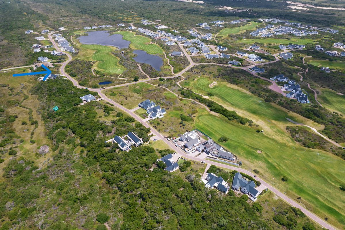 Aerial view of a residential estate featuring a golf course, natural landscape, and surrounding residential properties.