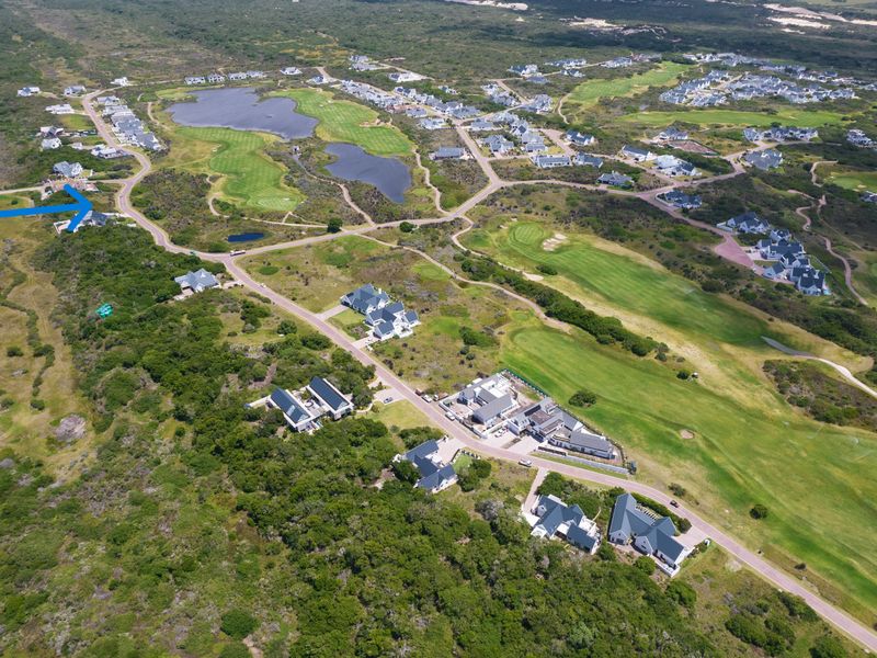 Aerial view of a residential estate featuring a golf course, natural landscape, and surrounding residential properties.