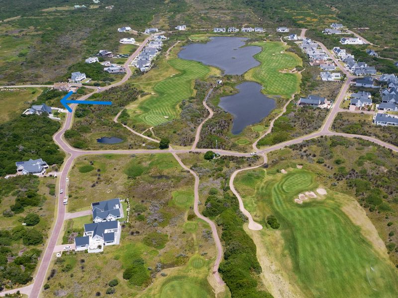 Aerial view of a residential estate featuring a golf course, natural landscape, and surrounding residential properties.