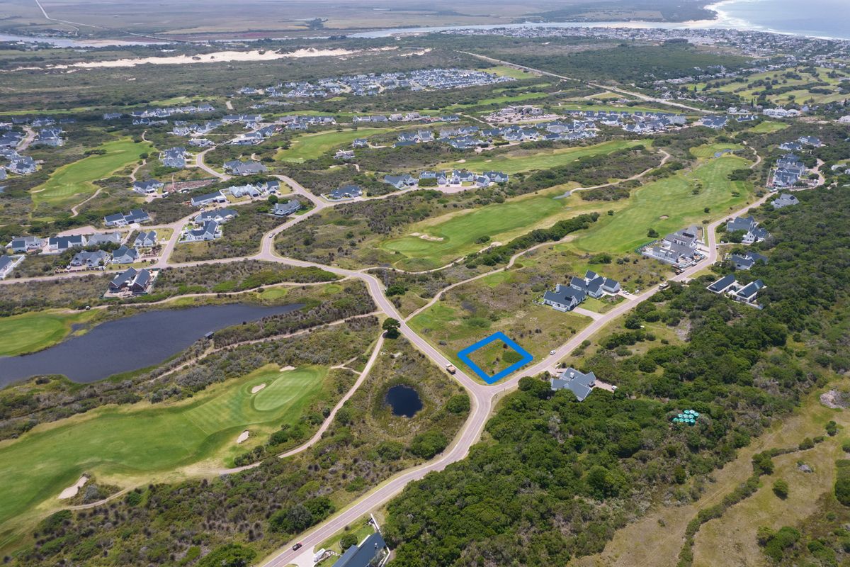 Aerial view of a vacant residential land plot situated within a scenic golf estate, offering convenient road access and surrounding natural landscape.