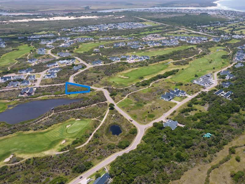 Aerial view of a vacant residential plot situated within a scenic golf estate, offering proximity to coastal amenities and natural surroundings.