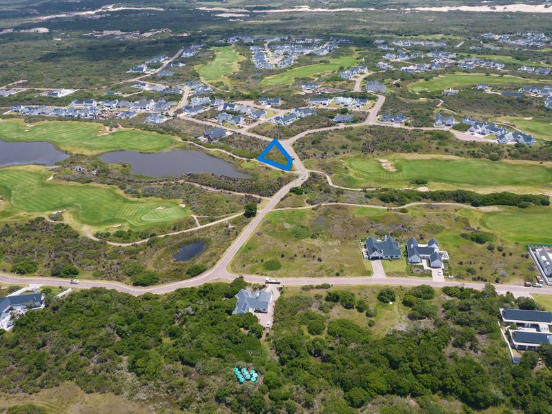 Aerial view of a vacant residential plot situated within a scenic golf estate, offering proximity to natural landscapes and established community infrastructure.