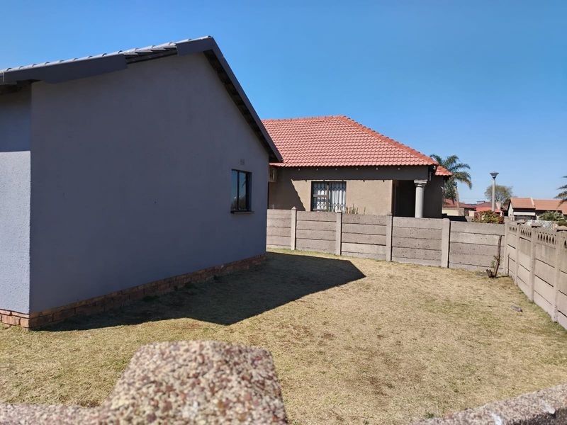 Rear view of the property showing a private garden area enclosed by precast concrete boundary walls and a section of the house exterior.