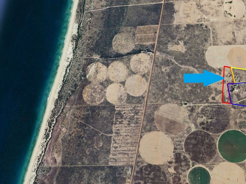 Aerial view of a coastal small holding property featuring agricultural land and irrigation circles.
