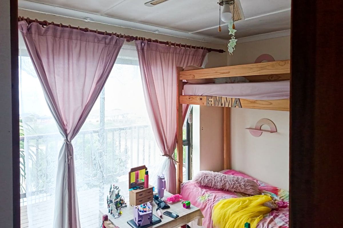 A bedroom featuring a ceiling fan and a sliding glass door providing access to an outdoor area.
