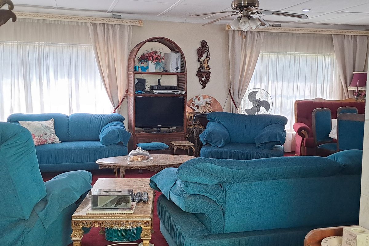 A spacious living room featuring a ceiling fan and large windows, offering a comfortable area for relaxation and family gatherings.
